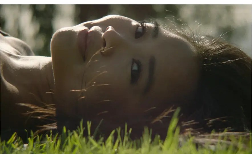 Film still of Kamryn in sunlit grass