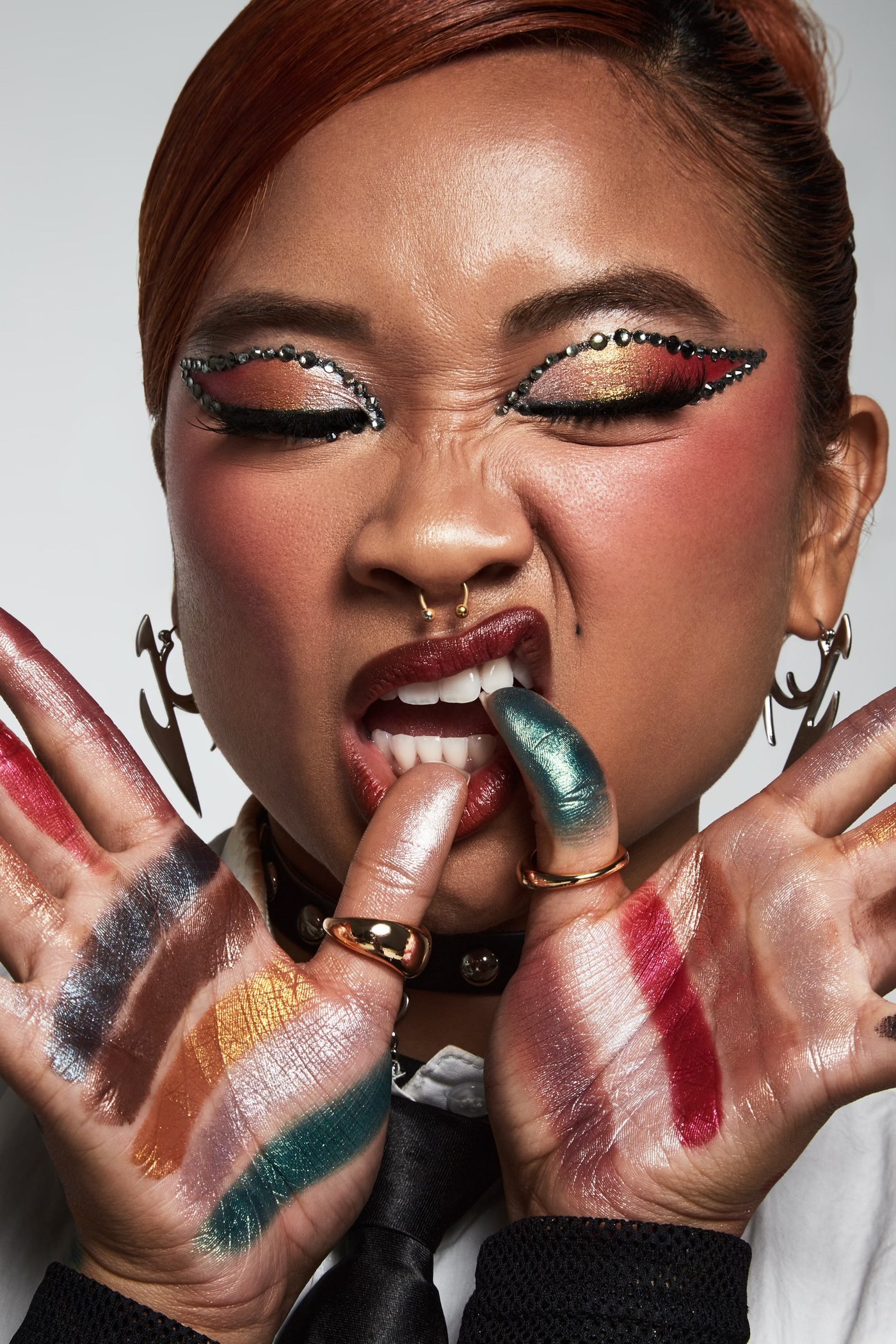 Kamryn Hernandez in a bold jewelled editorial beauty look, swatches painted across both palms